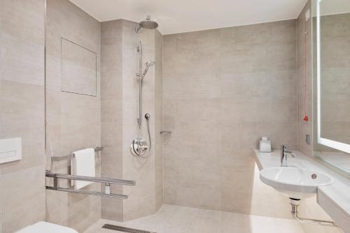 a bathroom with a shower and a sink at Courtyard by Marriott Munich Garching in Garching bei München
