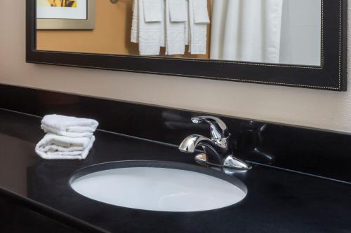 a bathroom sink with a black counter and a mirror at Fairfield Inn & Suites Temple Belton in Temple