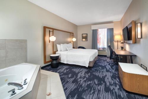 a hotel room with a bed and a sink and a tub at Fairfield Inn by Marriott Toronto Oakville in Oakville