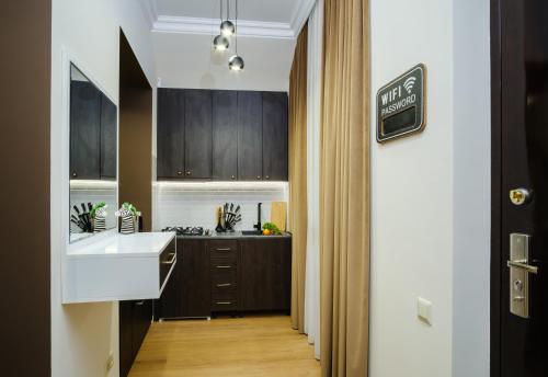 a kitchen with brown cabinets and a white sink at BB Residence Sololaki in Tbilisi City