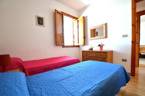 a bedroom with a blue bed and a dresser and a window at Casa vacanza vicino spiaggia-ll23 in San Foca