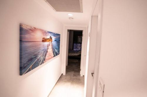 a hallway with a painting hanging on a wall at Sea View Boutique Apartment in Eilat