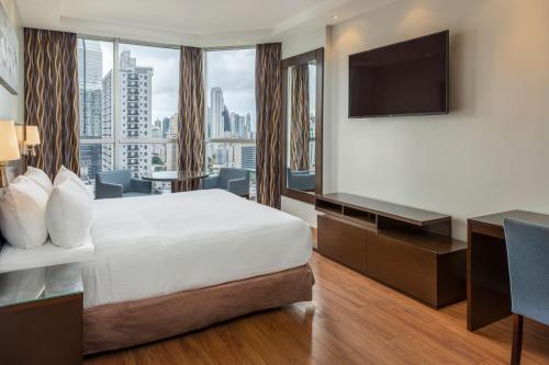 ein Hotelzimmer mit einem Bett und einem Flachbild-TV in der Unterkunft Marriott Executive Apartments Panama City, Finisterre in Panama-Stadt