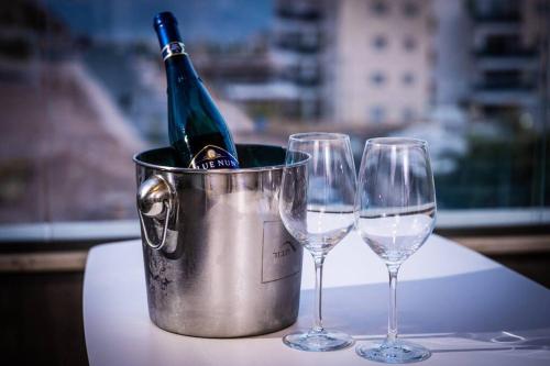 a bucket with a bottle of wine and two wine glasses at Sea View Boutique Apartment in Eilat