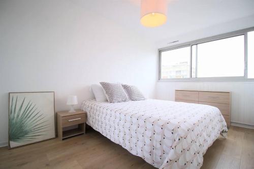 ein weißes Schlafzimmer mit einem Bett und einem Spiegel in der Unterkunft Ravissant trois pièces : Proche des Quais ! in Rouen