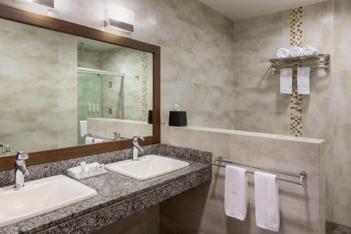 bagno con 2 lavandini e specchio di Marriott Executive Apartments Panama City, Finisterre a Città di Panama