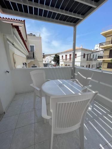 a white table and chairs on a balcony at Manto Apartments in Tinos Town