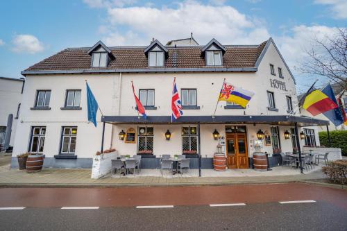 a white building with flags in front of it at Fletcher Hotel Restaurant De Geulvallei in Valkenburg