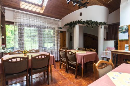 uma sala de jantar com mesas e cadeiras e uma grande janela em Mohacsi Guesthouse em Budapeste