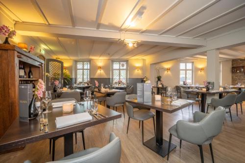 a restaurant with tables and chairs in a room at Fletcher Hotel Restaurant De Geulvallei in Valkenburg