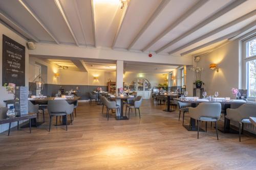 a restaurant with tables and chairs in a room at Fletcher Hotel Restaurant De Geulvallei in Valkenburg