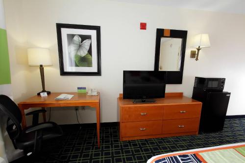 Habitación de hotel con escritorio y tocador con TV. en Fairfield Inn & Suites by Marriott Killeen en Killeen