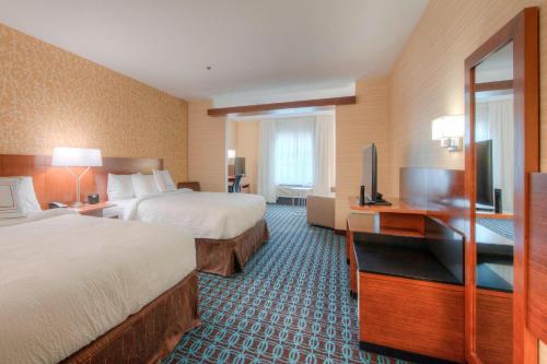 a hotel room with two beds and a flat screen tv at Fairfield Inn & Suites by Marriott Charlotte Airport in Charlotte