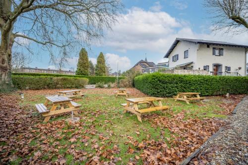 a group of picnic tables in a park at Fletcher Hotel Restaurant De Geulvallei in Valkenburg