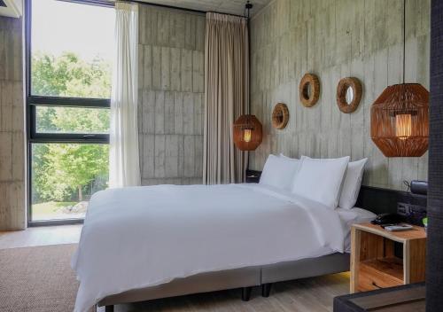 a bedroom with a large white bed and a window at Deer Chaser Hotel in Yuchi