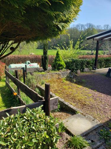 a garden with a wooden fence and some bushes at Chalet 176, Durbuy PROMO in Durbuy