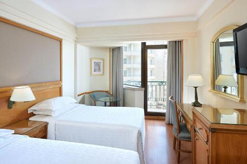 a hotel room with two beds and a balcony at Sheraton Montazah Hotel in Alexandria