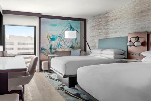 サンアントニオにあるMarriott San Antonio Airportのベッド2台とテーブルが備わるホテルルームです。