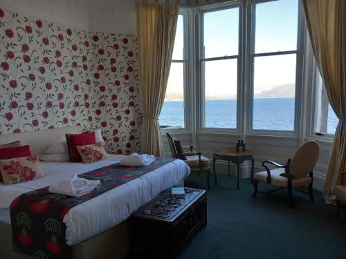 a hotel room with a bed with a view of the ocean at The Ardyne Guest House in Rothesay