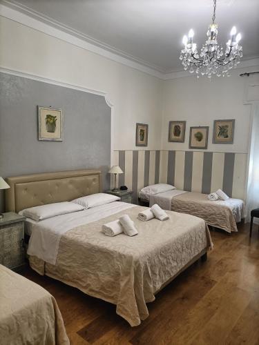 a hotel room with two beds and a chandelier at Al Teatro in Verona