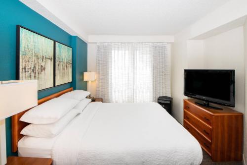 - une chambre avec un lit blanc et une télévision à écran plat dans l'établissement Residence Inn by Marriott Newark Silicon Valley, à Newark