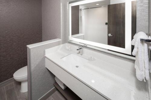 W łazience znajduje się biała umywalka i lustro. w obiekcie Fairfield Inn & Suites by Marriott Oklahoma City Downtown w mieście Oklahoma City