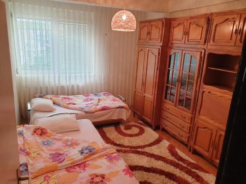 1 Schlafzimmer mit 2 Betten, einem Schrank und einem Teppich in der Unterkunft H Apartament in Pristina