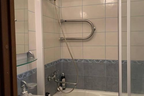 a shower with a hose attached to a bath tub at Just chill in Rīga