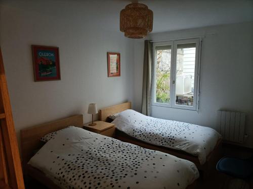 two beds in a room with a window at Appartement Saintes, centre historique in Saintes