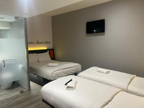 una camera d'albergo con due letti e una televisione di easyHotel Sheffield a Sheffield