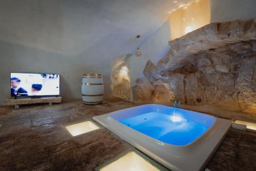 a bathroom with a bath tub and a tv at Arquati Suite Luxury Apartment in Ostuni
