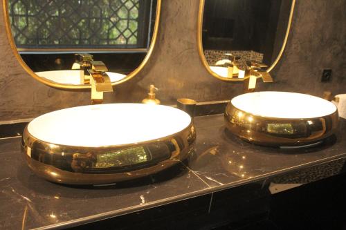 two sinks in a bathroom with two mirrors at Villa Le Petit Paradis Saly Boutique Hotel in Ngaparou