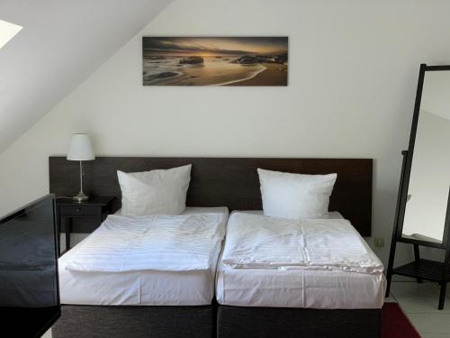 a bedroom with two beds with white sheets at Landhaus am Schaalsee in Zarrentin