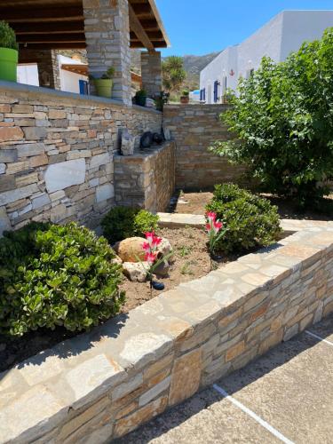 a stone retaining wall in a yard with flowers at Dream Catcher3 in Agia Theodoti
