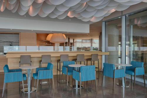 a bar with blue chairs and tables in a restaurant at Four Points by Sheraton Oran in Oran