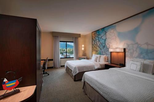 サン・サルバドルにあるCourtyard by Marriott San Salvadorのベッド2台と窓が備わるホテルルームです。