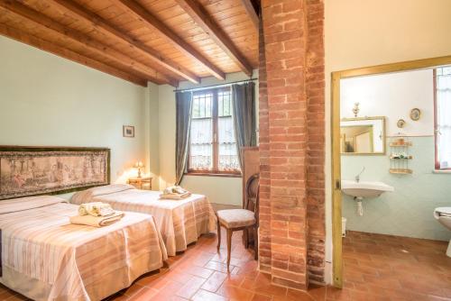 een slaapkamer met 2 bedden en een wastafel in een kamer bij Villa Il Fornacino in Rapolano Terme