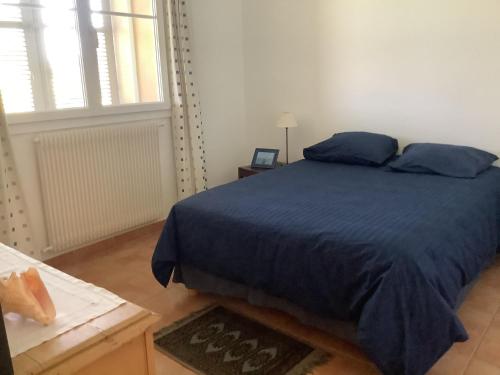 a bedroom with a blue bed with a blue blanket at Mas des Oliviers in Martigues