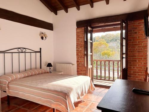 ein Schlafzimmer mit einem Bett und einem großen Fenster in der Unterkunft Apartamentos Camino del Norte in Cóbreces