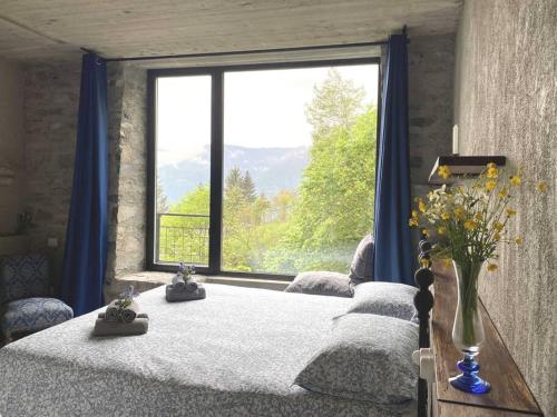 - une chambre avec un lit et une grande fenêtre dans l'établissement Casa 1000fiori, à Faggeto Lario 