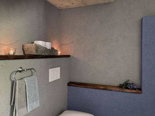La salle de bains est pourvue de toilettes et d'une étagère avec des serviettes. dans l'établissement Casa 1000fiori, à Faggeto Lario 