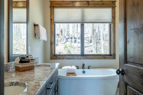een badkamer met 2 wastafels en een groot raam bij Grayling Lodge at Eagles Nest in Banner Elk