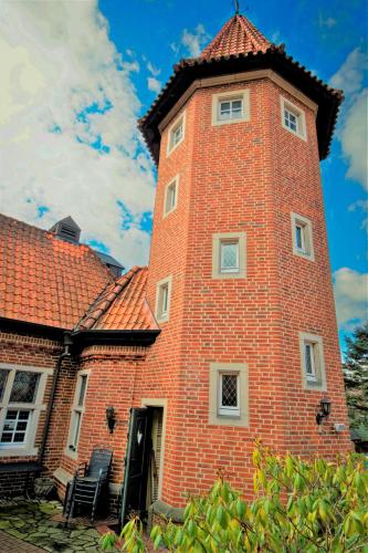 a tall brick building with a red roof at Burghotel Haselünne in Haselünne