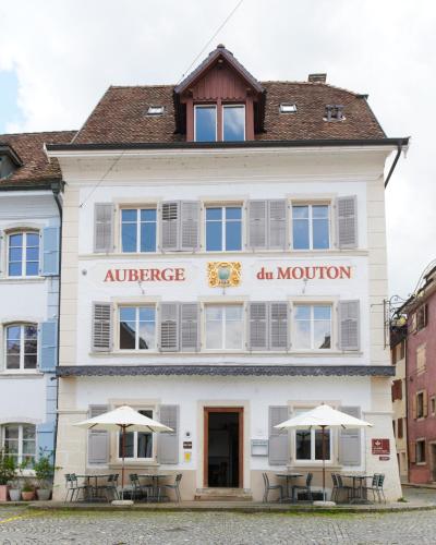a white building with umbrellas in front of it at Auberge du Mouton in Porrentruy