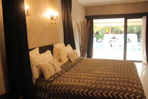 a bedroom with a bed with white pillows and a window at Villa Le Petit Paradis Saly Boutique Hotel in Ngaparou