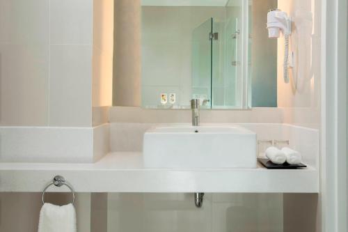 a bathroom with a white sink and a mirror at Fairfield by Marriott Surabaya in Surabaya