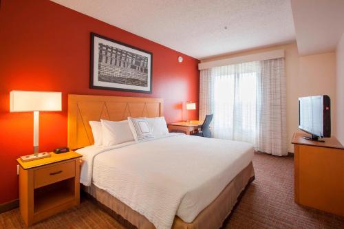 グッドイヤーにあるResidence Inn Phoenix Goodyearのベッド1台、薄型テレビが備わるホテルルームです。
