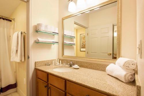 a bathroom with a sink and a large mirror at Residence Inn Phoenix Goodyear in Goodyear