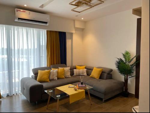 a living room with a gray couch with yellow pillows at Solaris Premium Luxury Living in Accra