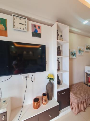 a living room with a flat screen tv on a wall at Italian Inspired Tropical-Themed Studio Condo in Davao City